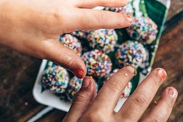 istock childrens hand taking colorful sweets from wooden desk 511599704