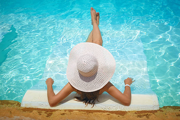 istock beautiful woman in white hat sitting on the edge of 511600388