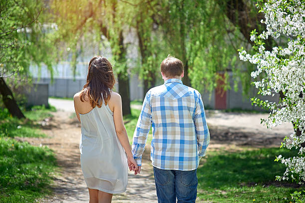 istock Young happy couple walking in spring park 511600902