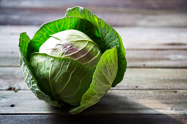 frischer grüner gartenkohl auf rustikalem holzhintergrund - cabbage stock-fotos und bilder