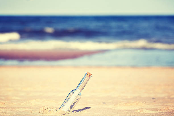 istock Vintage toned message in a bottle on beach. 511601428
