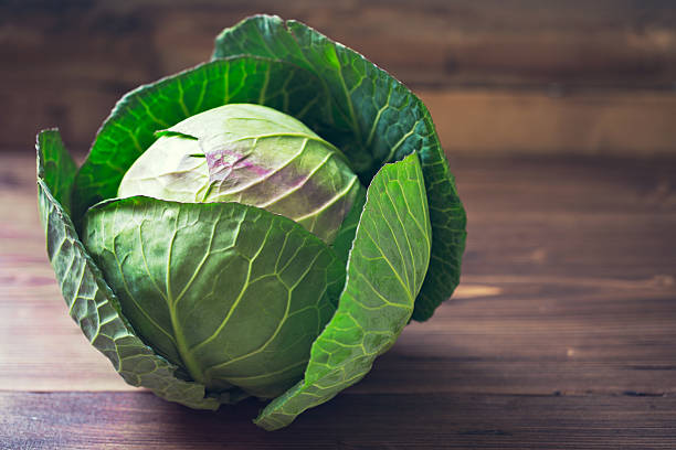 istock Fresh green garden cabbage on rustic wooden background 511601584