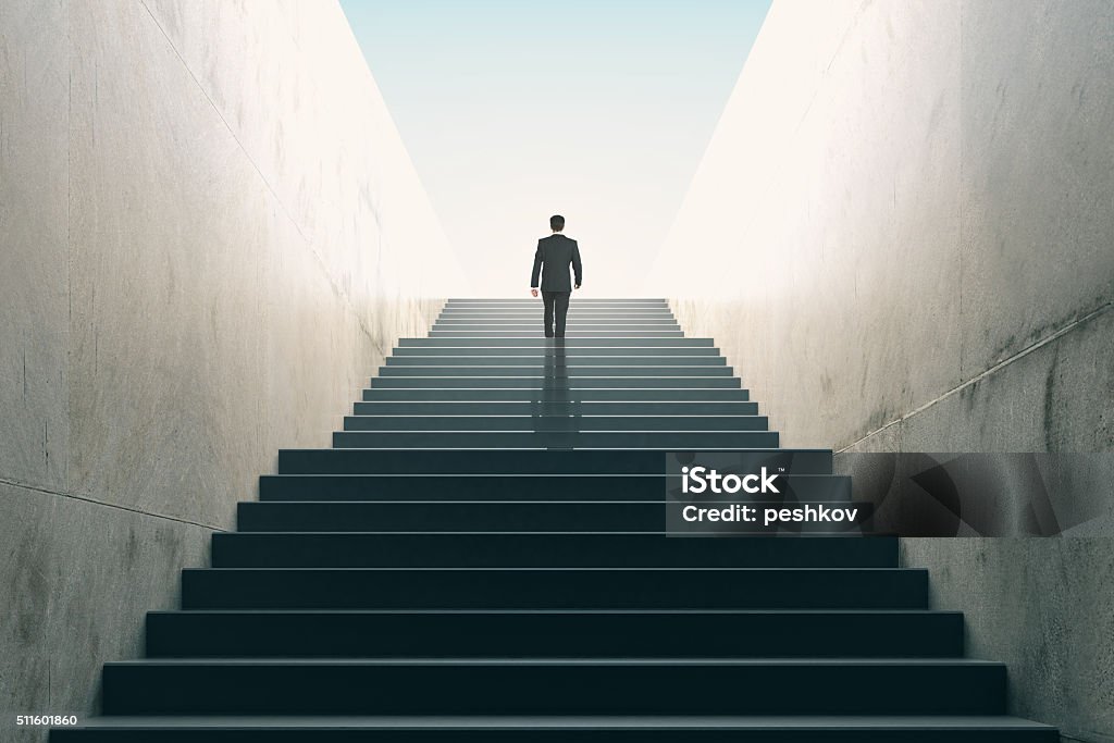 Ambitions concept with businessman climbing stairs Business Stock Photo