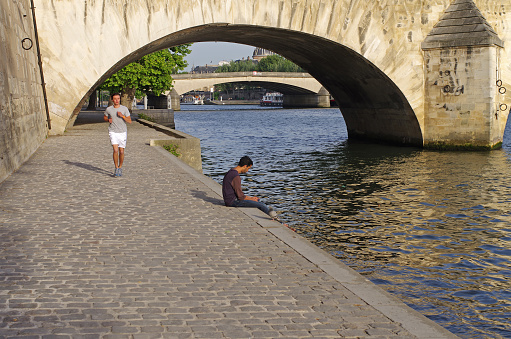 Paris, France - May 24, 2011: Seine embankment in early summer evening. A man jogging along the waterfront