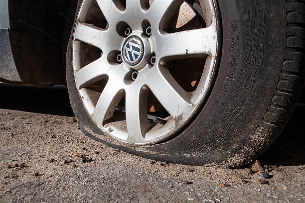 Vilnius, Lithuania - October 25, 2015: Flat tire on VW Vilnius, Lithuania - October, 25, 2015 Flat tire on an VW Vehicle parked on a city street. rubber rocks stock pictures, royalty-free photos & images