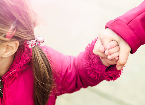 istock Child walking and holding hands with her parent 511604096