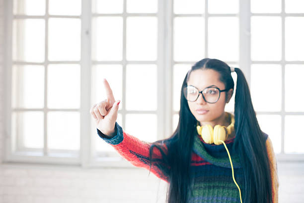 istock Asian woman with headphones touching virtual display 511605720