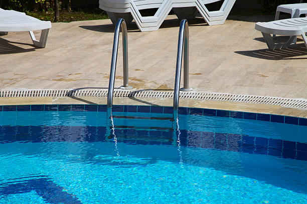istock Shiny chrome ladder in the pool with blue water 511607110