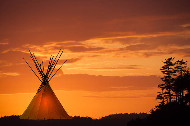 istock Teepee at sunset with gold and orange sky 511607952