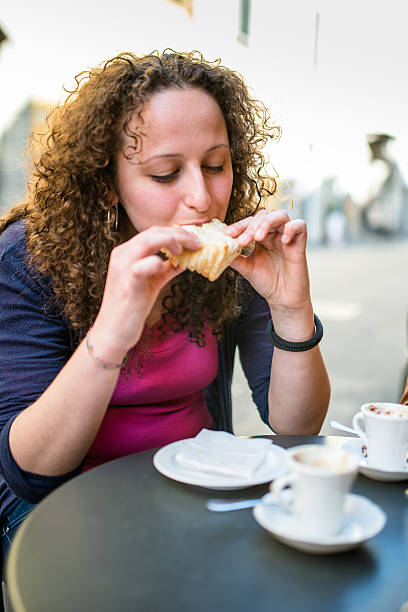 istock woman biting a snack at the cafe 511608702