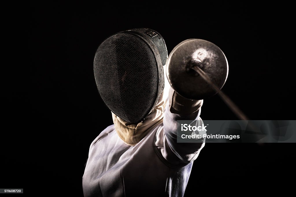 Fencing sport. Portrait of woman wearing white fencing costume practicing with the sword. Activity Stock Photo