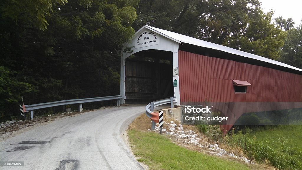 Indiana red covered bridge Side view and entrance to a historical red wooden covered bridge named Newport, 1885. Summertime in Indiana, next to trees Bridge - Built Structure Stock Photo