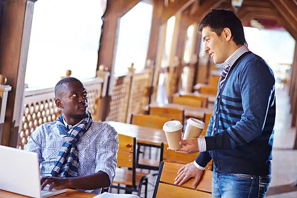 College student bringing coffee for him and his friend