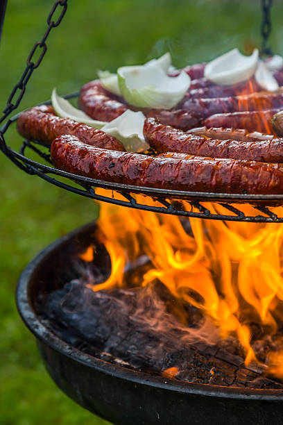 roasting sausages with onions on fire in the garden