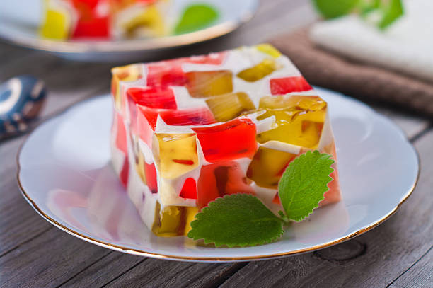 frutas laticínios, geleia de vermelho e verde em um prato. - gelatin dessert - fotografias e filmes do acervo