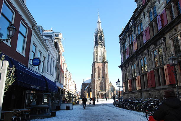 Delft (Netherlands) daily, snowy main square, people blue sky Delft, Netherlands - January 31, 2010: daily and snowy main square of Delft in the Netherlands in the morning with people and blue sky as lifestyle on January 31, 2010 in Delft, Netherlands as editorial delft winter netherlands snow stock pictures, royalty-free photos & images