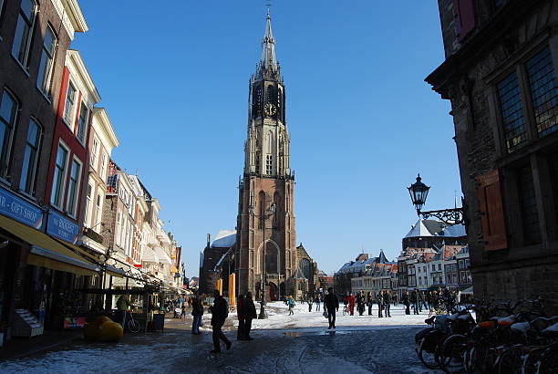 Delft (Netherlands) daily, snowy main square, people blue sky Delft, Netherlands - January 31, 2010: daily and snowy main square of Delft in the Netherlands in the morning with people and blue sky as lifestyle on January 31, 2010 in Delft, Netherlands as editorial delft winter netherlands snow stock pictures, royalty-free photos & images