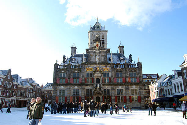 Delft (Netherlands) daily, snowy main square, people blue sky Delft, Netherlands - January 31, 2010: daily and snowy main square of Delft in the Netherlands in the morning with people and blue sky as lifestyle on January 31, 2010 in Delft, Netherlands as editorial delft winter netherlands snow stock pictures, royalty-free photos & images