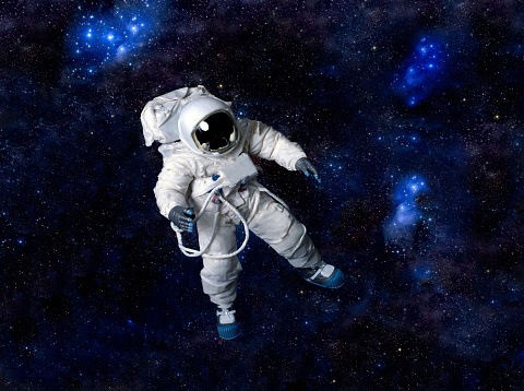 Astronaut wearing pressure suit against a space background.