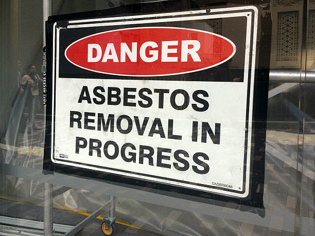 Sign reads: Danger - Asbestos removal in progress Auckland, New Zealand - October 21, 2015: Sign reads: Danger - Asbestos removal in progress. Inhalation of asbestos fibers can cause serious and fatal illnesses including lung cancer, mesothelioma and asbestosis. auckland region photos stock pictures, royalty-free photos & images