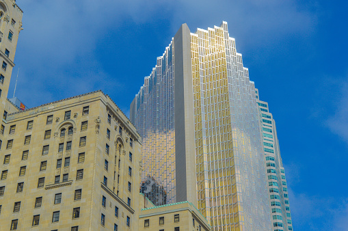 Toronto, Canada - June 13, 2015: Gold skyscraper and the old fashioned Fairmont Royal York Hotel within financial and entertainment districts in downtown.