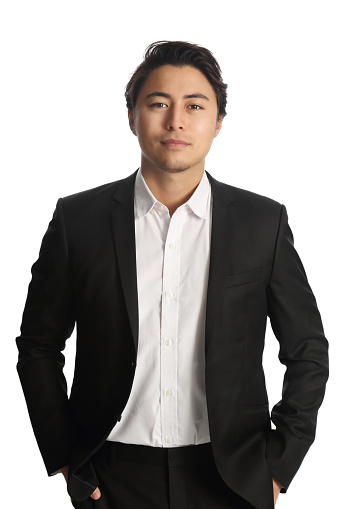 An attractive businessman wearing a black blazer with a white shirt, standing against a white background looking at camera. Smile on his face. 