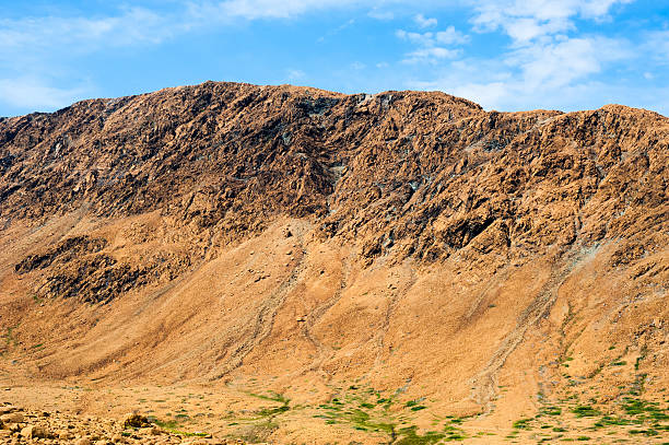 istock Rocky dry yellow cliff ridge with eroded channels 511656640
