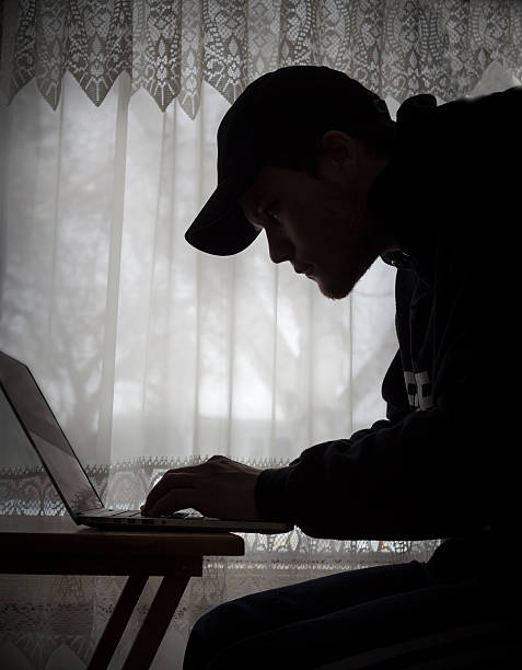 istock silhouette image of a guy sitting at his laptop. 511657052
