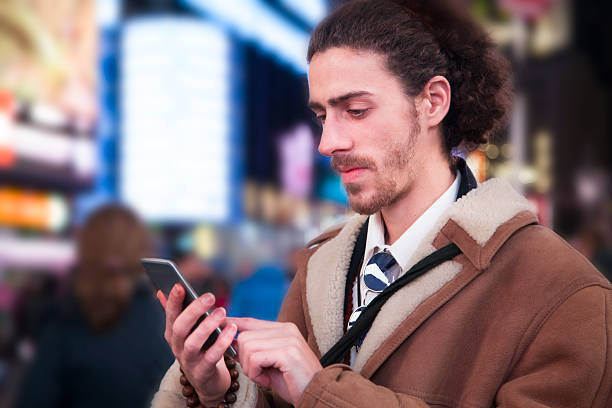 istock Man with cell phone in Times Square, New York City. 511657426