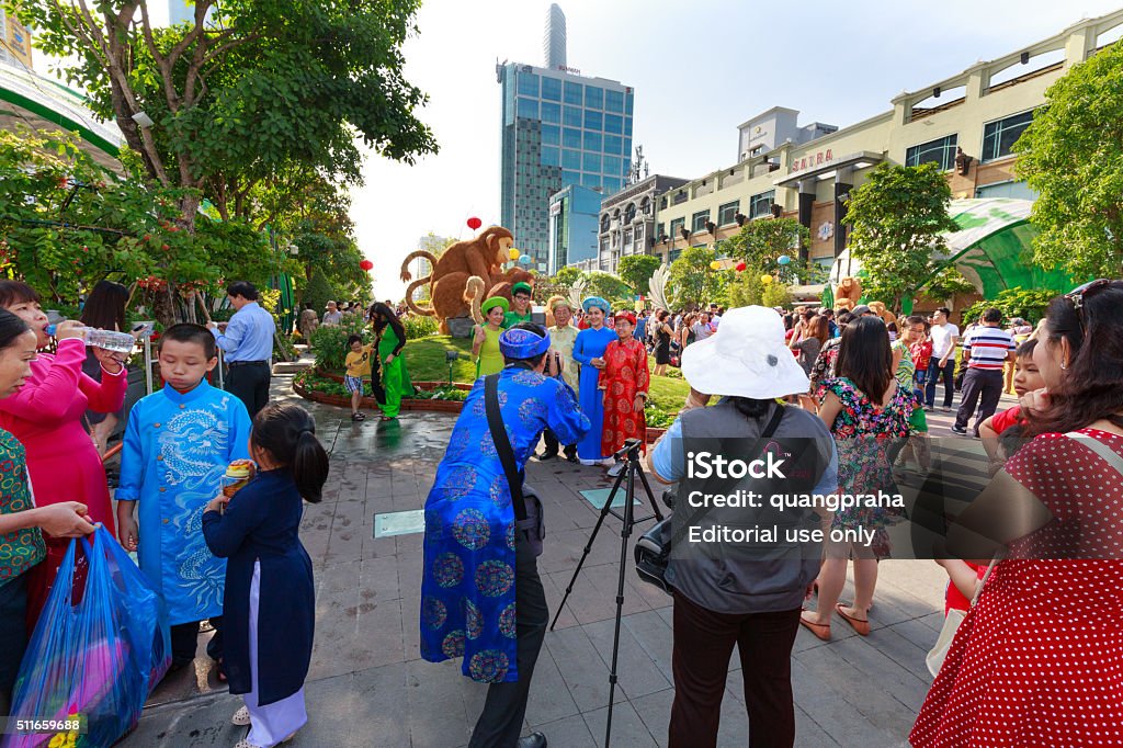 Nguyen Hue street walk in the Lunar New Year Hochiminh City, Vietnam - February 07, 2016 : in the atmosphere of welcoming the New Lunar Year . a big family wearing traditional dress standing pose for taking souvenir photos on flower street Nguyen Hue downtown HoChiMinh city Adult Stock Photo