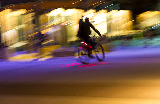 istock Colorful Blurred Cyclist at Night Against Illuminated Shops 511660490