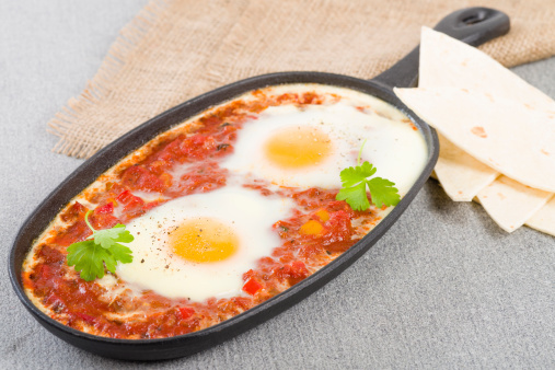 Eggs poached in tomato sauce served with tortillas.