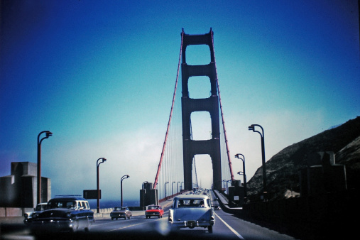 Vintage 1962 scanned slide of Golden Gate Bridge traffic. Several classic Ford cars. Horizontal.