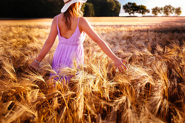 istock Woman Walking Through Wheat Field 511665333