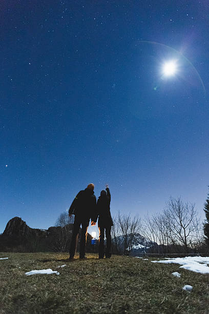 istock Couple looks comet in the night sky 511665405