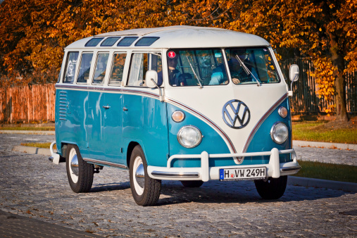 Szczecin, Poland - August 30, 2014:Two men in renovated Volkswagen Transporter Type 2 (T1) drives paved road on the outskirts Szczecin city. Volkswagen Transporter Type 2 (T1) was produced from 195 to 1967