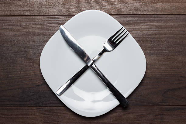 istock dieting concept white plate with knife and fork crossed 511666245