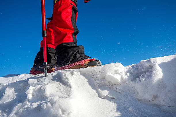 istock walking on snow with Snow shoes and Shoe spikes. 511666498