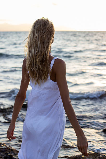 istock Woman relaxing at sea at sunset 511668377
