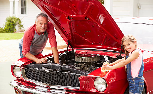 istock Grandfather And Granddaughter Working On Classic Car 511669063