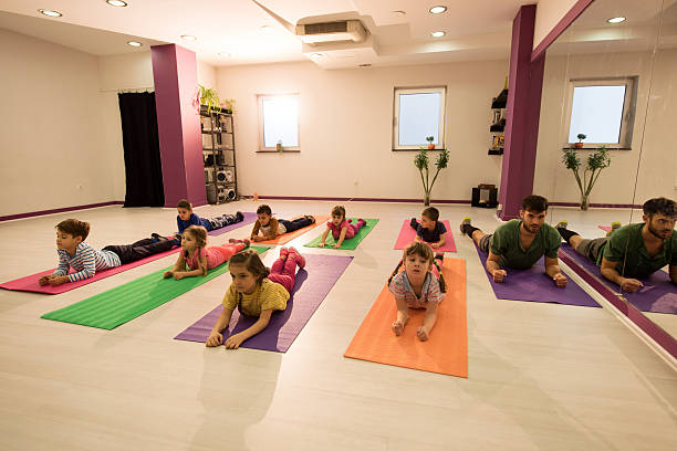 istock Small kids exercising with young instructor in health club. 511669072