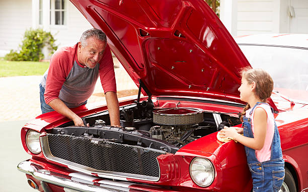 istock Grandfather And Granddaughter Working On Classic Car 511669119