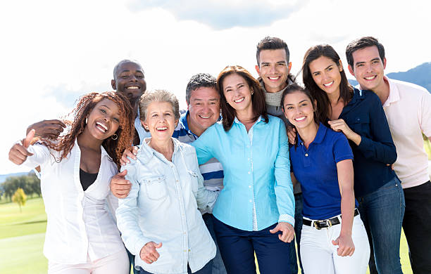 Large group of happy athletic friends having fun while taking a selfie with mobile phone in the park.