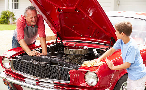 istock Grandfather And Grandson Working On Restored Classic Car 511669499