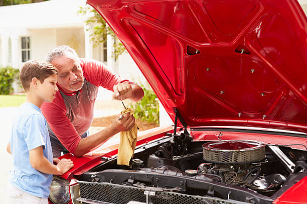 istock Grandfather And Grandson Working On Restored Classic Car 511669595