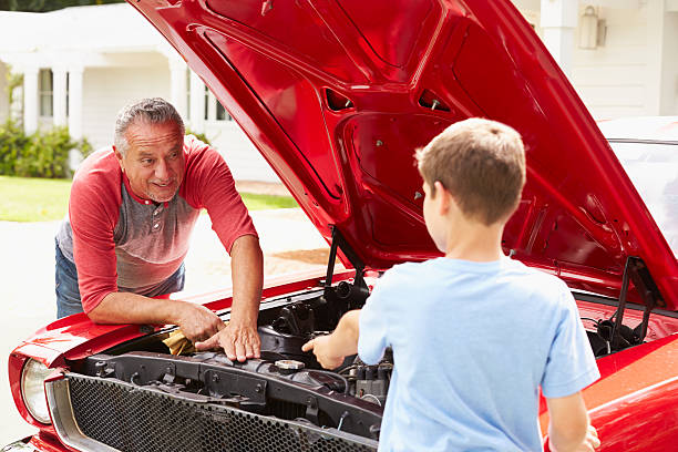 istock Grandfather And Grandson Working On Restored Classic Car 511669661