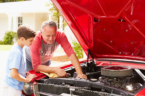 istock Grandfather And Grandson Working On Restored Classic Car 511669789