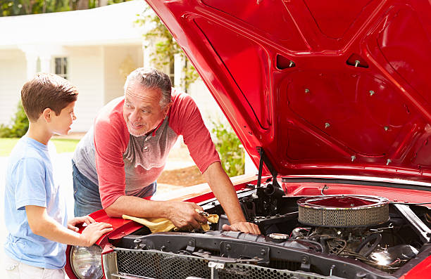 istock Grandfather And Grandson Working On Restored Classic Car 511669795