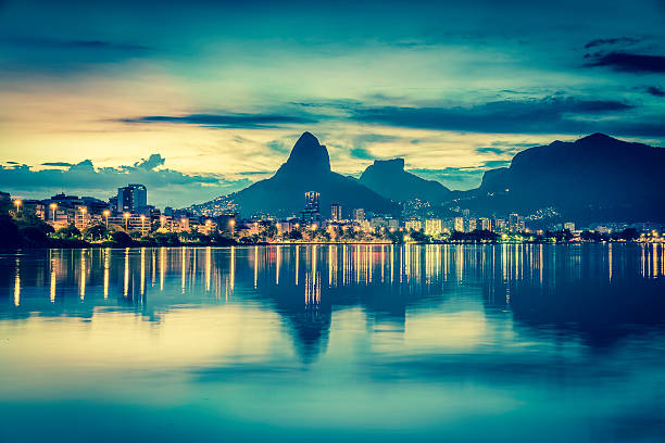 Sunset behind mountains in Rio de Janeiro with water reflection, Brazil