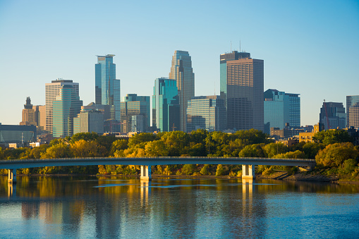 View of Downtown Minneapolis with the Mississippi River and a bridge during the early morning of an Autumn day.